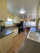 Kitchen featuring stainless steel appliances, light hardwood / wood-style flooring, ceiling fan, and sink