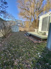 View of yard with a storage unit and a wooden deck