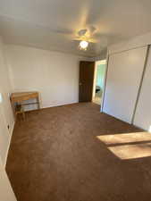 Unfurnished bedroom featuring carpet flooring, ceiling fan, and a closet