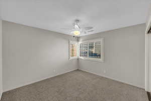 Empty room featuring ceiling fan and carpet