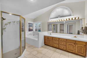 Bathroom with separate shower and tub, tile patterned flooring, vanity, and vaulted ceiling