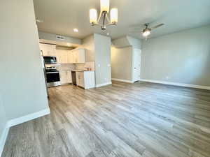 Kitchen featuring white cabinets, sink, decorative backsplash, appliances with stainless steel finishes, and light hardwood / wood-style floors