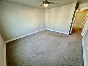 Spare room featuring carpet flooring and ceiling fan