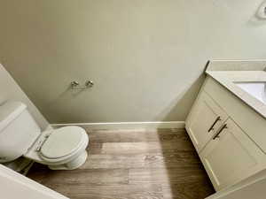 Bathroom featuring hardwood / wood-style floors, vanity, and toilet