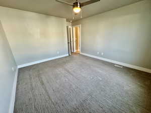 Carpeted spare room with ceiling fan