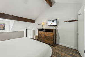 Bedroom with dark wood-type flooring and lofted ceiling with beams