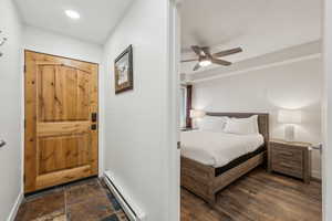 Bedroom featuring ceiling fan and a baseboard heating unit