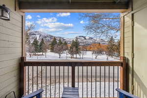 Snow covered back of property with a mountain view