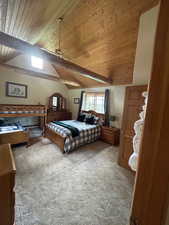 Bedroom with vaulted ceiling with beams, carpet floors, and wood ceiling