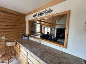 Interior space featuring tile patterned flooring and rustic walls