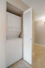 Washroom featuring stacked washer / drying machine