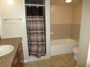 Full bathroom featuring plus walk in shower, tile patterned flooring, vanity, and toilet