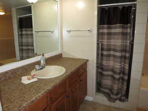 Bathroom featuring a shower with curtain, vanity, and tile patterned floors