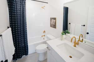 Full bathroom featuring tile patterned flooring, vanity, toilet, and shower / bathtub combination with curtain