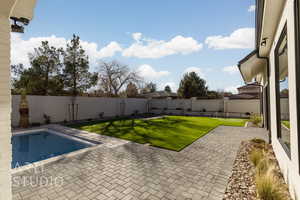 View of swimming pool featuring a yard and a patio