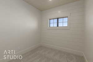 Carpeted empty room featuring lofted ceiling