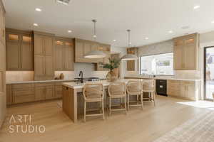 Kitchen with decorative backsplash, an island with sink, light hardwood / wood-style floors, and decorative light fixtures