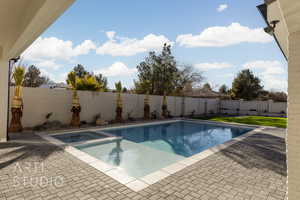 View of swimming pool with an in ground hot tub and a patio