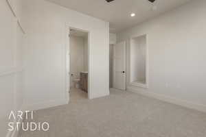 Unfurnished bedroom featuring light carpet and connected bathroom