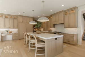 Kitchen with backsplash, pendant lighting, light brown cabinets, light hardwood / wood-style floors, and an island with sink