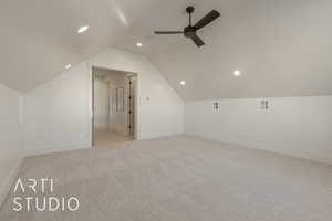 Bonus room featuring light colored carpet, vaulted ceiling, and ceiling fan