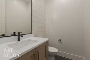 Bathroom with toilet, vanity, and tile patterned floors