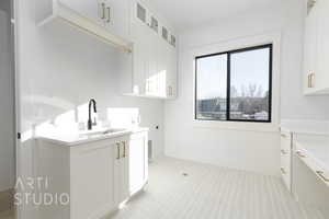 Laundry room with cabinets, hookup for a washing machine, hookup for an electric dryer, and sink