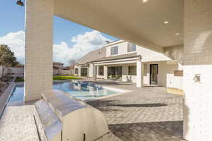 View of pool with a patio and an outdoor kitchen