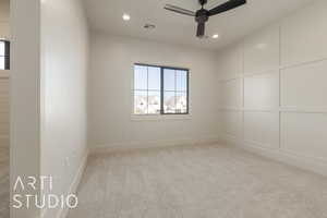 Carpeted spare room featuring ceiling fan