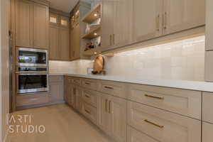 Kitchen with decorative backsplash, light wood-type flooring, oven, and built in microwave