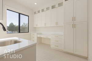 Kitchen featuring light tile patterned flooring, white cabinetry, and sink