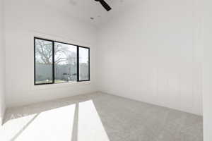 Empty room with ceiling fan and light colored carpet