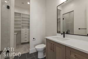 Bathroom featuring tile patterned flooring, vanity, toilet, and walk in shower