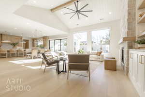 Living room with beam ceiling, ceiling fan, high vaulted ceiling, light hardwood / wood-style floors, and a fireplace