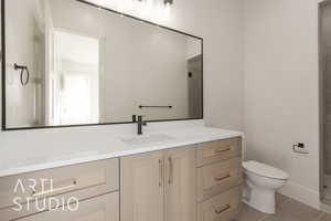 Bathroom with tile patterned flooring, vanity, toilet, and walk in shower