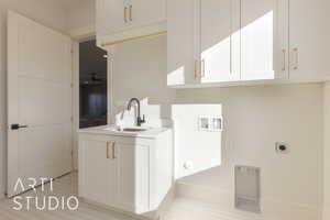 Washroom featuring cabinets, hookup for a washing machine, ceiling fan, electric dryer hookup, and sink