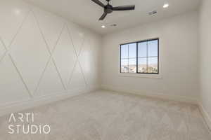 Carpeted spare room featuring ceiling fan