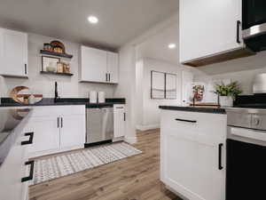 Kitchen with white cabinetry, sink, stainless steel dishwasher, white range, and light wood-type flooring