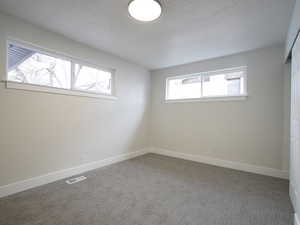 Spare room featuring carpet flooring and a textured ceiling