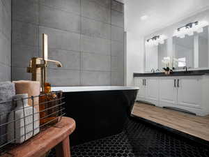 Bathroom featuring a textured ceiling, vanity, and tile walls