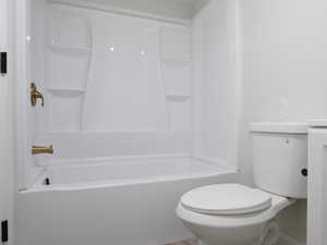 Bathroom featuring shower / bath combination, hardwood / wood-style flooring, and toilet