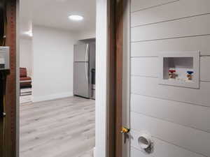 Interior space featuring washer hookup and wooden walls