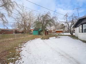 Snowy yard with a storage shed