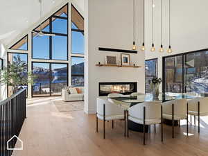 Dining room with a mountain view, hardwood / wood-style flooring, and high vaulted ceiling