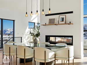 Dining area featuring a multi sided fireplace, a mountain view, and light wood-type flooring