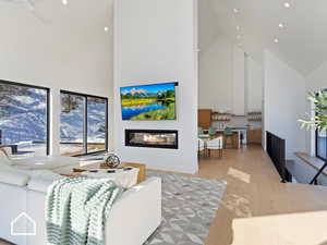 Living room with light wood-type flooring and high vaulted ceiling