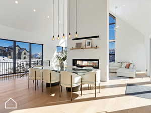 Dining space with light hardwood / wood-style floors and a high ceiling