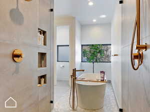 Bathroom with a tub to relax in and tile patterned floors