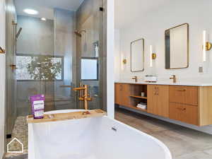 Bathroom featuring shower with separate bathtub and vanity