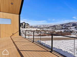 Snow covered back of property with a mountain view